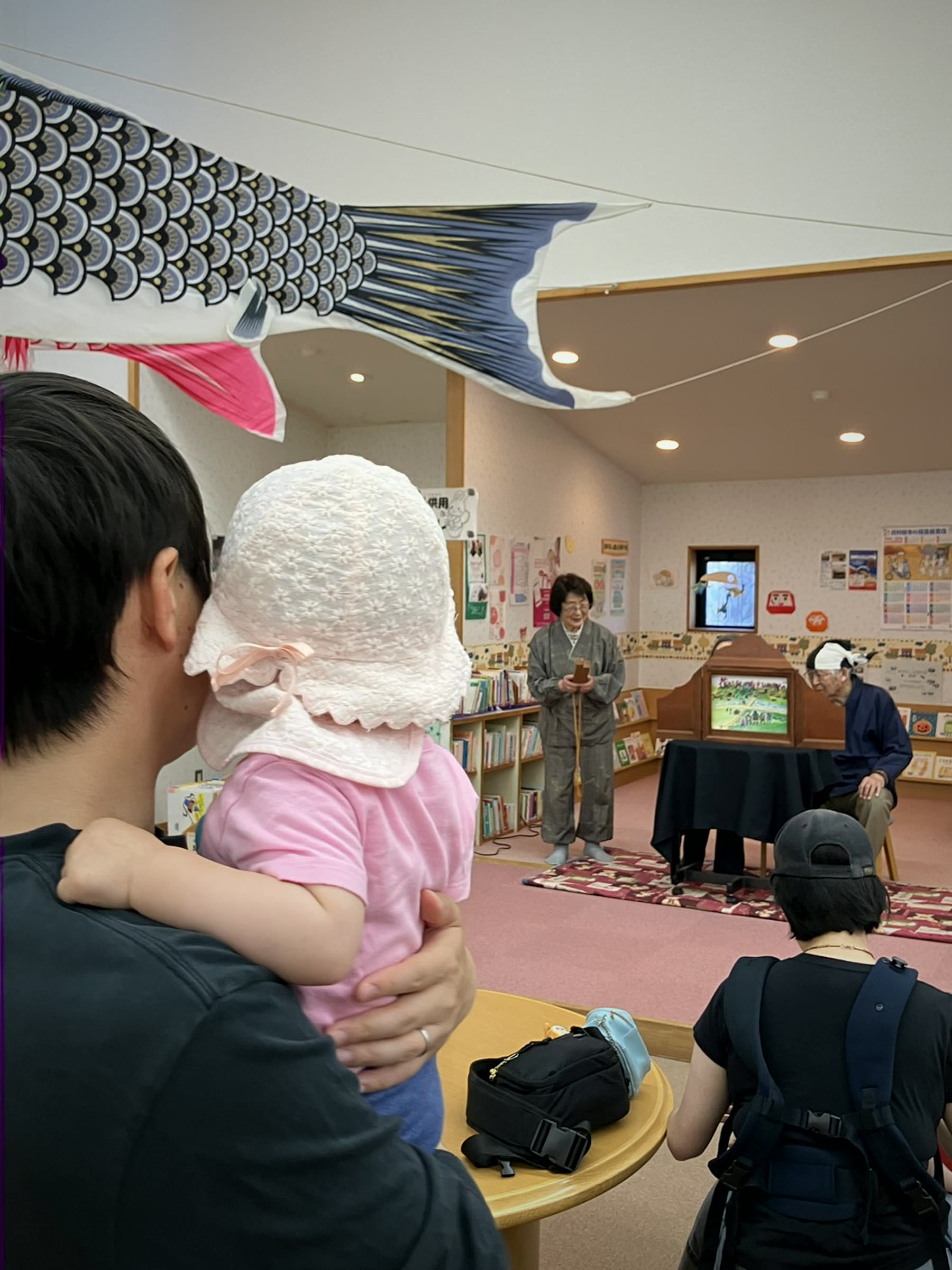 親子が図書館のお話会を見ている様子